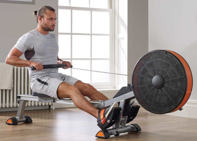 Мужчина тренирует выносливость на гребном тренажере